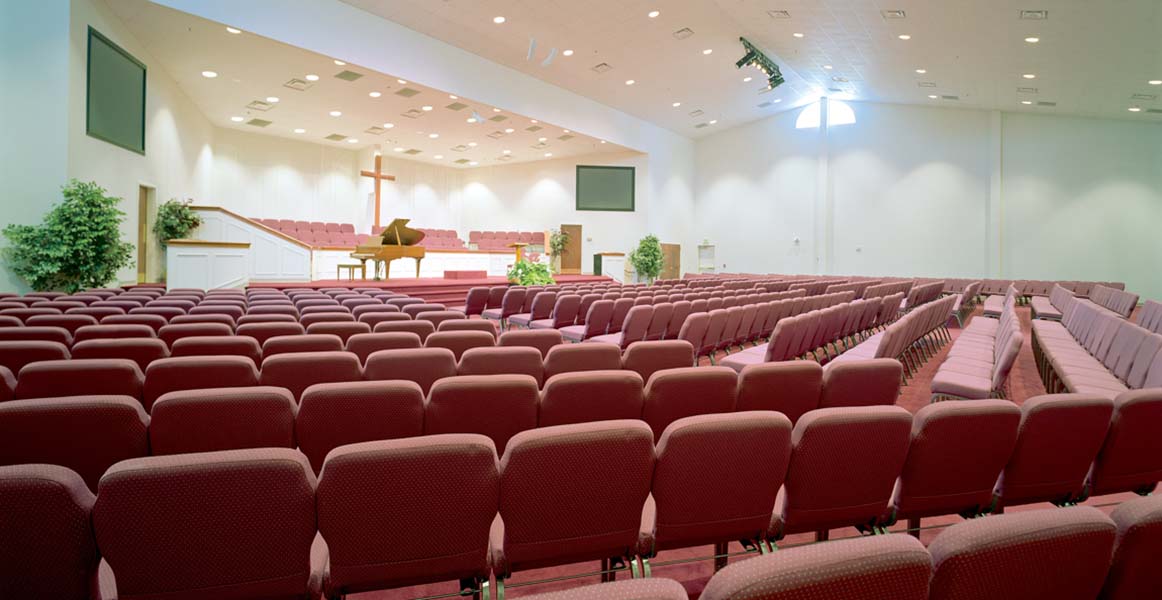 Espace de culte très ouvert et soigné avec des chaises de culte Bertolini rouges