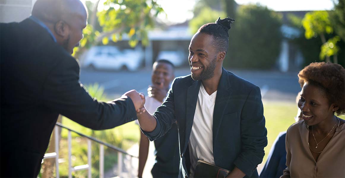 Young family greeting church leader upon entry