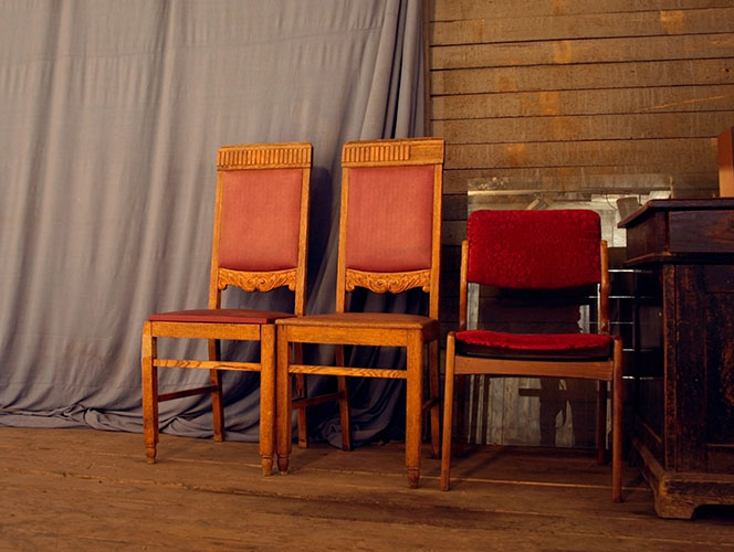 mismatched and old faded chairs in an old church setting