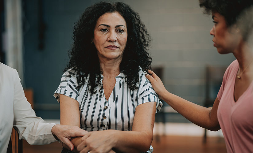 A woman being consoled by fellow worshipers